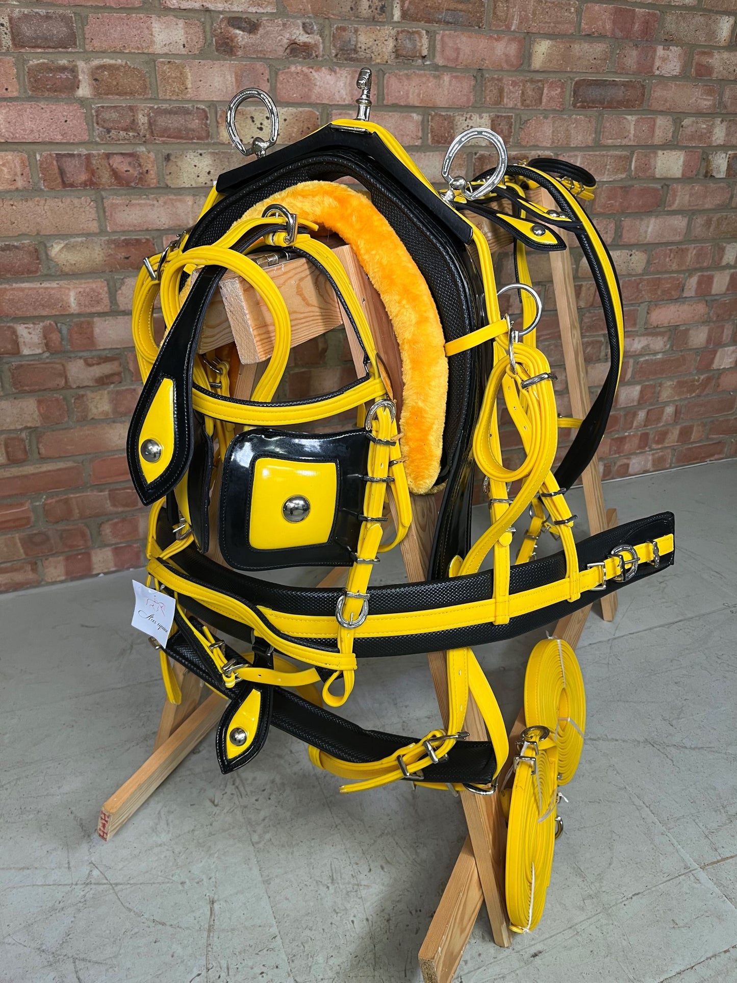 A yellow and black breeching harness with soft bio-thane padding, horse shoe buckle, and square winkers
