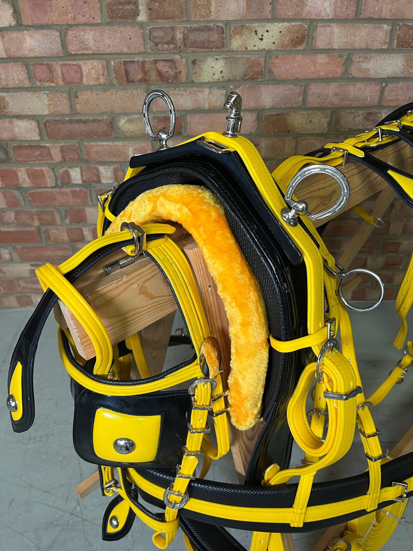 A yellow and black breeching harness with soft bio-thane padding, horse shoe buckle, and square winkers