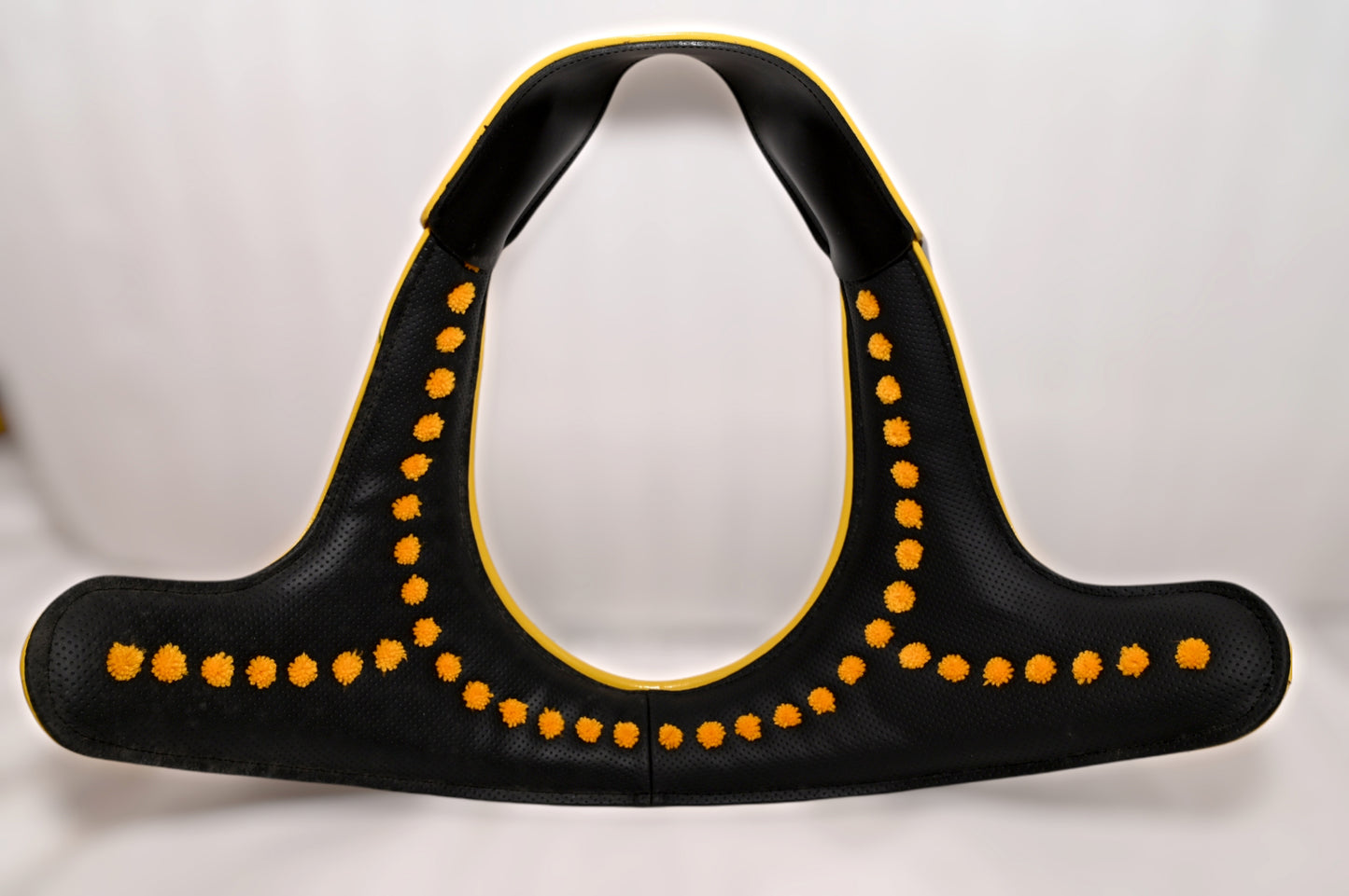 A black and yellow soft padded brollar for horses